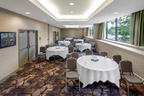 a conference room with tables and chairs and windows at Holiday Inn & Suites Pittsfield-Berkshires by IHG in Pittsfield