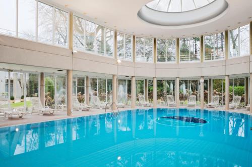 een groot zwembad in een gebouw met glazen ramen bij Holiday Inn Resort le Touquet, an IHG Hotel in Le Touquet-Paris-Plage