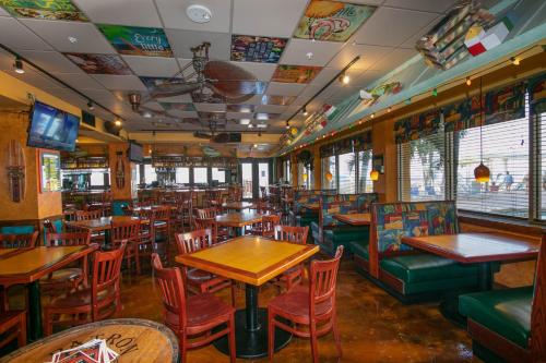 a restaurant with wooden tables and chairs and tables andwindows at Holiday Inn & Suites Clearwater Beach by IHG in Clearwater Beach