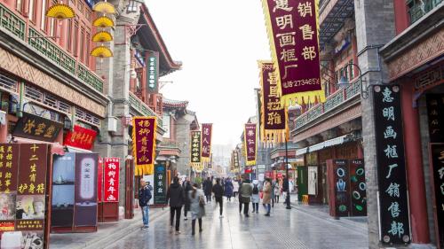 a group of people walking down a city street with signs at Holiday Inn & Suites Tianjin Downtown by IHG in Tianjin