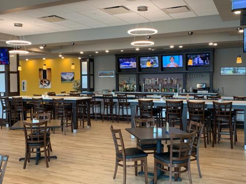 a restaurant with tables and chairs and televisions at Holiday Inn & Suites - Jefferson City by IHG in Jefferson City