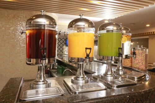 three different types of drinks in glass containers on a counter at Holiday Inn Hotel & Suites Centro Historico by IHG in Guadalajara
