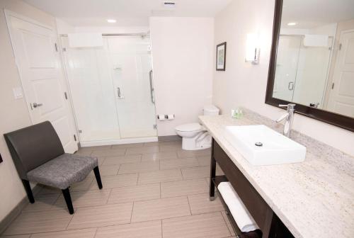 a bathroom with a sink and a toilet and a mirror at Holiday Inn Hotel & Suites Red Deer by IHG in Red Deer