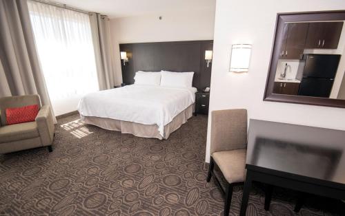 a hotel room with a bed and a desk and chair at Holiday Inn Hotel & Suites Red Deer by IHG in Red Deer