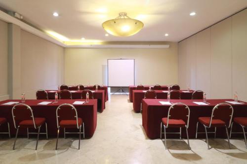 a conference room with red tables and chairs and a whiteboard at Holiday Inn Hotel & Suites Centro Historico by IHG in Guadalajara