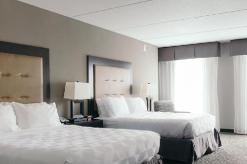 a hotel room with two beds and a window at Holiday Inn and Suites East Peoria by IHG in Peoria
