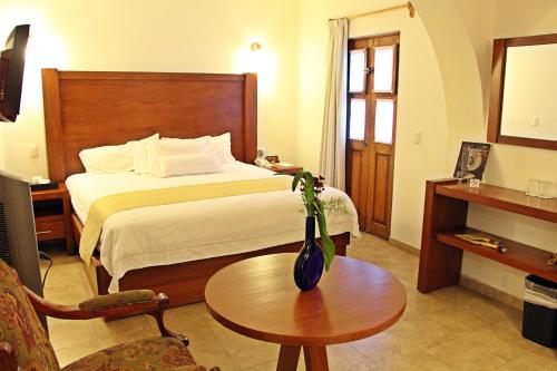 a hotel room with a bed and a table at El Serafin Hotel Boutique in Querétaro