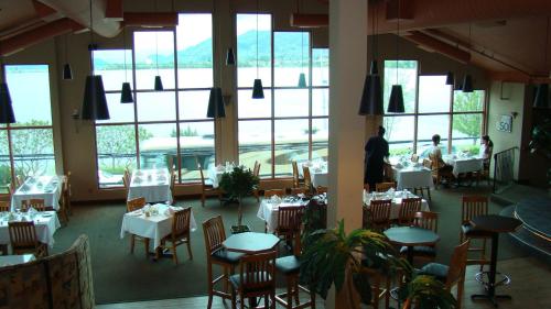 a dining room with tables and chairs and windows at Holiday Inn Hotel & Suites Osoyoos by IHG in Osoyoos