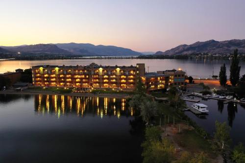 a hotel on a lake at night with the lights on at Holiday Inn Hotel & Suites Osoyoos by IHG in Osoyoos