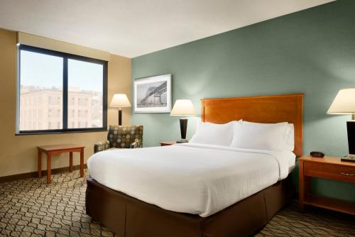 ダルースにあるHoliday Inn & Suites Duluth-Downtown by IHGの大きなベッドと窓のあるホテルの部屋