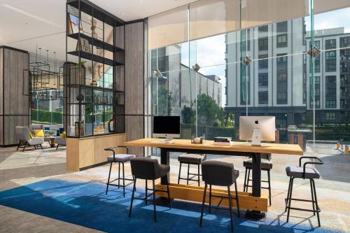 an office with a table with chairs and a laptop on it at Holiday Inn & Suites Siracha Laemchabang by IHG in Si Racha