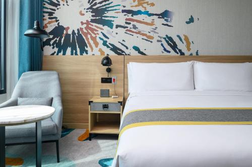 a hotel room with a bed and a chair at Holiday Inn & Suites Siracha Laemchabang by IHG in Si Racha