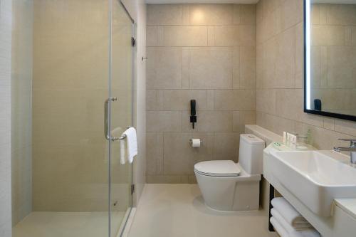 a bathroom with a shower and a toilet and a sink at Holiday Inn & Suites Siracha Laemchabang by IHG in Si Racha