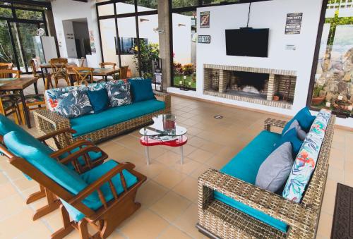 sala de estar con sofás, sillas y chimenea en Hotel Casa Portones en San Bernardo