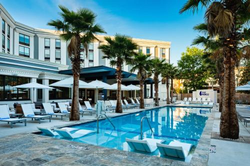 a hotel pool with palm trees and lounge chairs at Hotel Indigo Mount Pleasant by IHG in Charleston