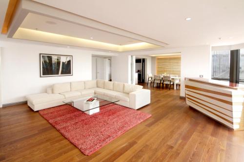 a living room with a white couch and a red rug at Presidente InterContinental Guadalajara by IHG in Guadalajara