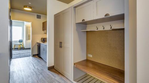 a kitchen with white cabinets and a door leading into a room at Holiday Inn & Suites Bellingham by IHG in Bellingham