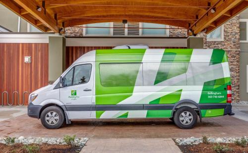a green and white van parked in front of a building at Holiday Inn & Suites Bellingham by IHG in Bellingham