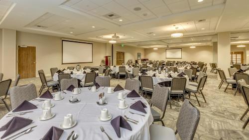 a conference room with tables and chairs and a screen at Holiday Inn & Suites Bellingham by IHG in Bellingham