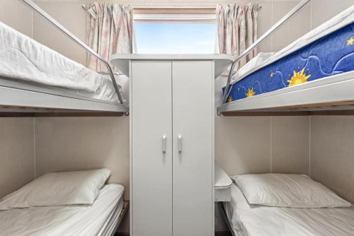 a small room with two bunk beds and a window at Discovery Parks - Clare in Clare