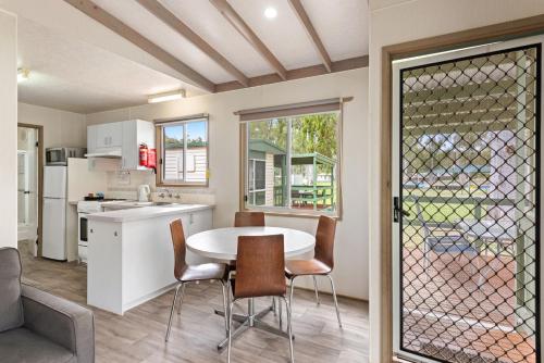 a kitchen and dining room with a table and chairs at Discovery Parks - Clare in Clare