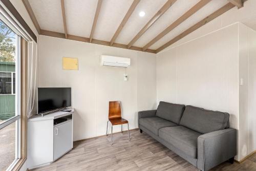 a living room with a couch and a television at Discovery Parks - Clare in Clare