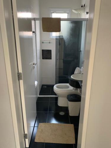 a small bathroom with a toilet and a sink at Morada da Praia - Casa in Bertioga