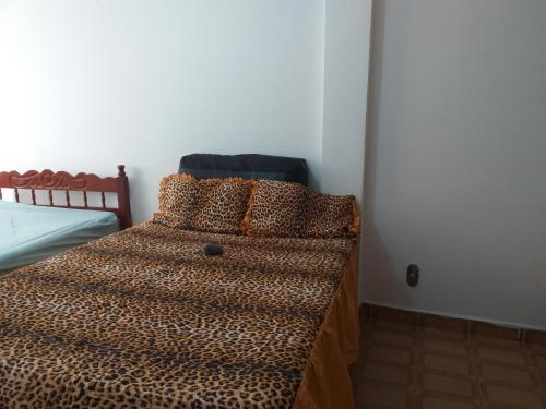 - un lit avec une couette en plumes de léopard dans une chambre dans l'établissement Apartamento Carrinho do Kuko n 309, à Praia Grande