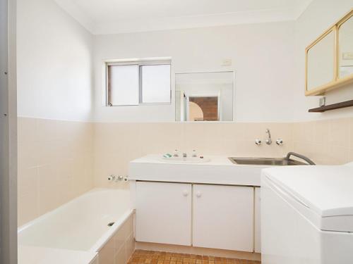 ein weißes Badezimmer mit einem Waschbecken und einer Badewanne in der Unterkunft Allamanda Court Unit 6 in Tweed Heads