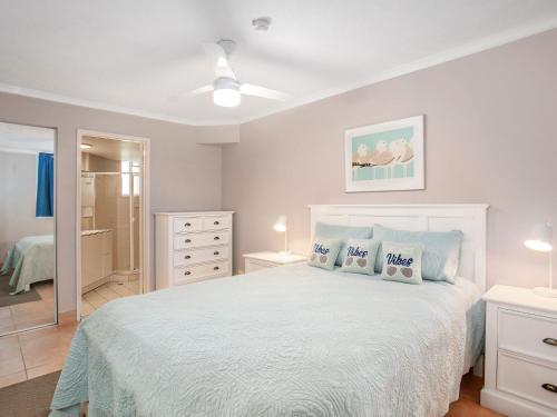 1 dormitorio con 1 cama blanca y 2 almohadas en Bay Apartments Unit 10 en Gold Coast
