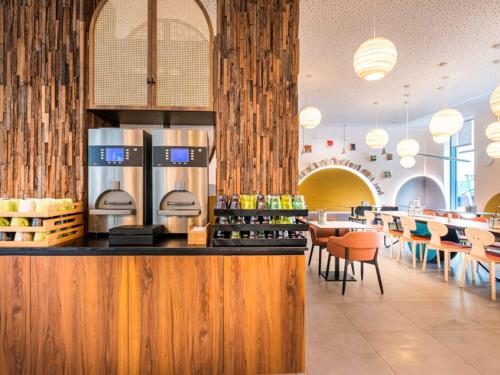 a restaurant with a counter and tables and chairs at ibis Styles Paris Meteor Avenue d'Italie in Paris