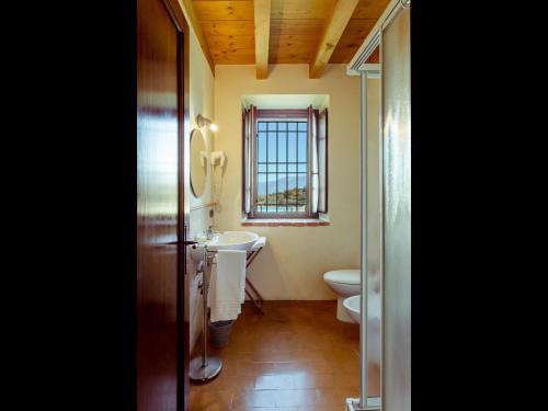 a bathroom with a sink and a toilet and a window at Belvilla by OYO Bilo Grande della Cascina in Salò