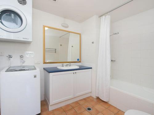 a bathroom with a sink and a mirror and a tub at Calypso Plaza Resort Unit 146 in Gold Coast