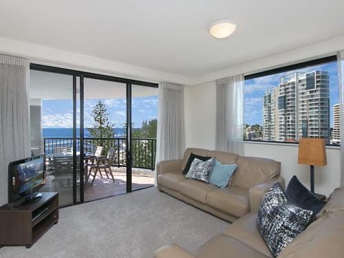 a living room with a couch and a view of the ocean at Calypso Tower Unit 807 in Gold Coast