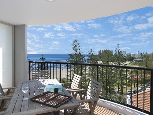 a table and chairs on a balcony with a view of the ocean at Calypso Tower Unit 807 in Gold Coast