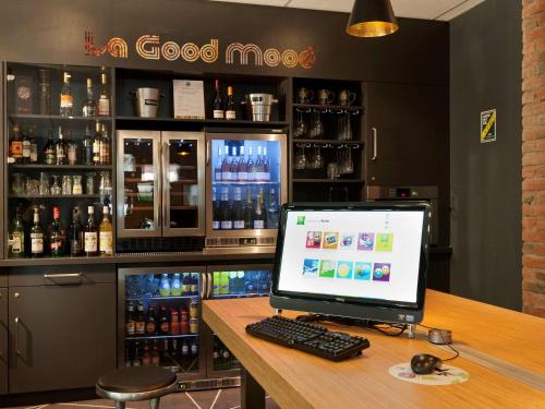 a computer sitting on a desk in a bar at ibis Styles Roanne Centre Gare in Roanne