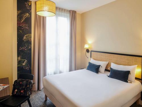 a hotel room with a large bed and a window at Ibis Styles Nantes Centre Place Graslin in Nantes