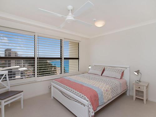 una camera bianca con un letto e una finestra di Carool Unit 25 a Gold Coast