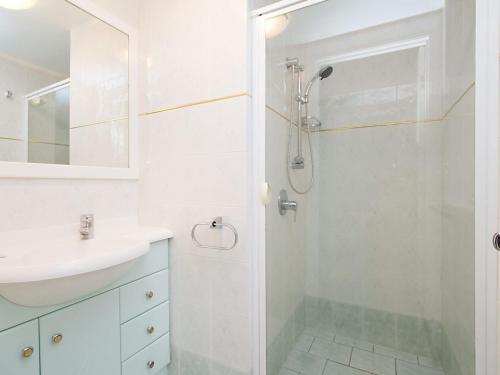 a white bathroom with a shower and a sink at Classique Unit 3 in Gold Coast