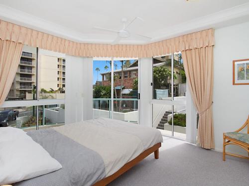 a bedroom with a bed and a large window at Classique Unit 3 in Gold Coast