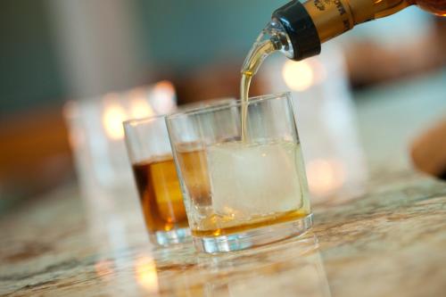 a drink being poured into a glass on a table at Hotel Indigo Waco by IHG in Waco
