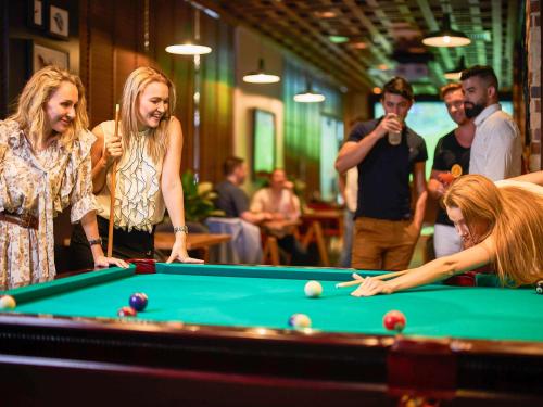 a group of women standing around a pool table at Mercure Dubai Barsha Heights Hotel Suites And Apartments in Dubai