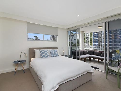 ein Schlafzimmer mit großem Bett und Balkon in der Unterkunft Eden Apartments Unit 502 in Gold Coast