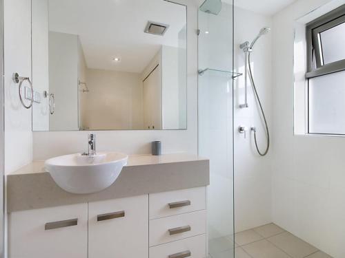 ein weißes Badezimmer mit Waschbecken und Dusche in der Unterkunft Eden Apartments Unit 502 in Gold Coast