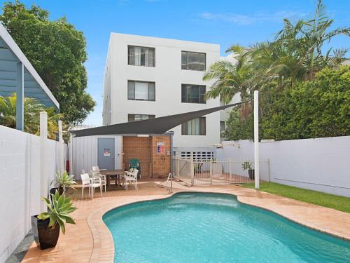 a house with a swimming pool in front of a house at Kirra Vista Apartments Unit 18 in Gold Coast