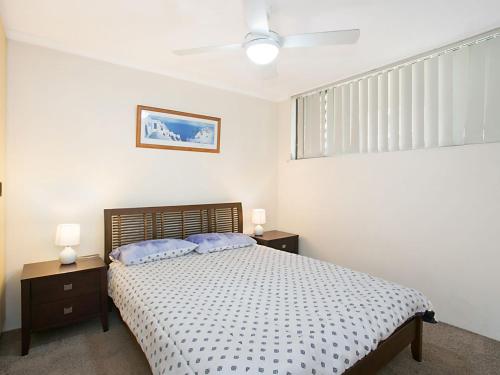 a bedroom with a bed with two blue pillows at Kirra Gardens Unit 30 in Gold Coast