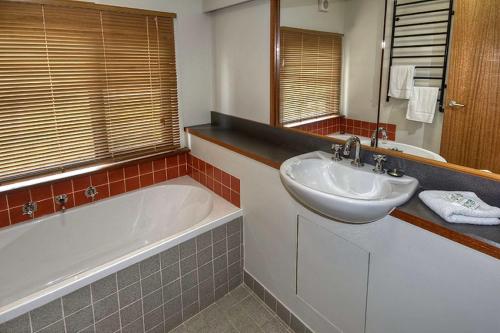 a bathroom with a tub and a sink and a bath tub at Delmonte in Medlow Bath