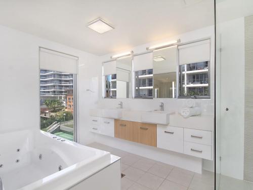 - Baño blanco con 2 lavabos y ducha en Maili 6 Luxury sky home, en Gold Coast