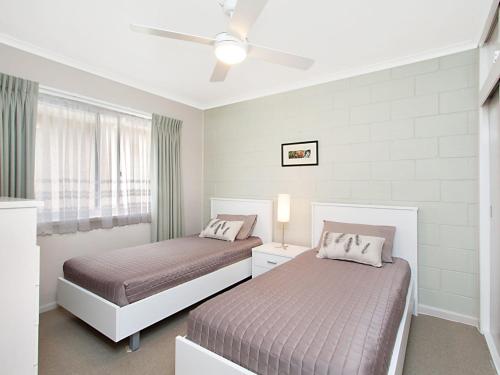 a bedroom with two beds and a ceiling fan at Mavic Court Unit 4 in Gold Coast