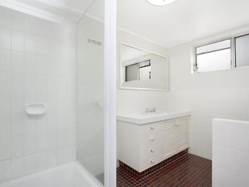 a white bathroom with a sink and a shower at Maybury Unit 1 in Gold Coast